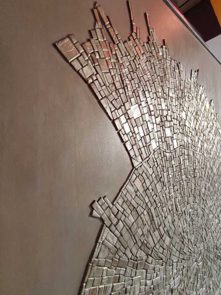 Detail of beige and gold textured mosaic wall art with fossil-inspired abstract design on tone-on-tone background