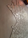 Detail of beige and gold textured mosaic wall art with fossil-inspired abstract design on tone-on-tone background