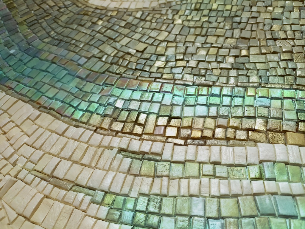 Close up of abstract mosaic wall art with taupe, grey, brown and light blue colors in textured wave pattern