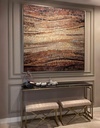 Mosaic wall art featuring a wave pattern in amber, brick, and brown tones with a creamy sand-colored center
