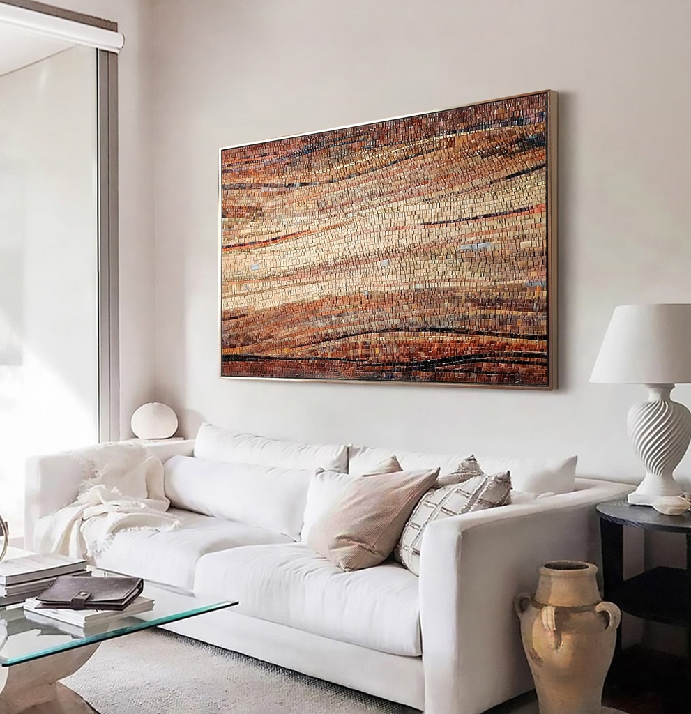 Mosaic wall art featuring a wave pattern in amber, brick, and brown tones with a creamy sand-colored center