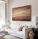 Mosaic wall art featuring a wave pattern in amber, brick, and brown tones with a creamy sand-colored center