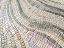 Close up of mosaic wall art with pastel green, lavender, and gold tones