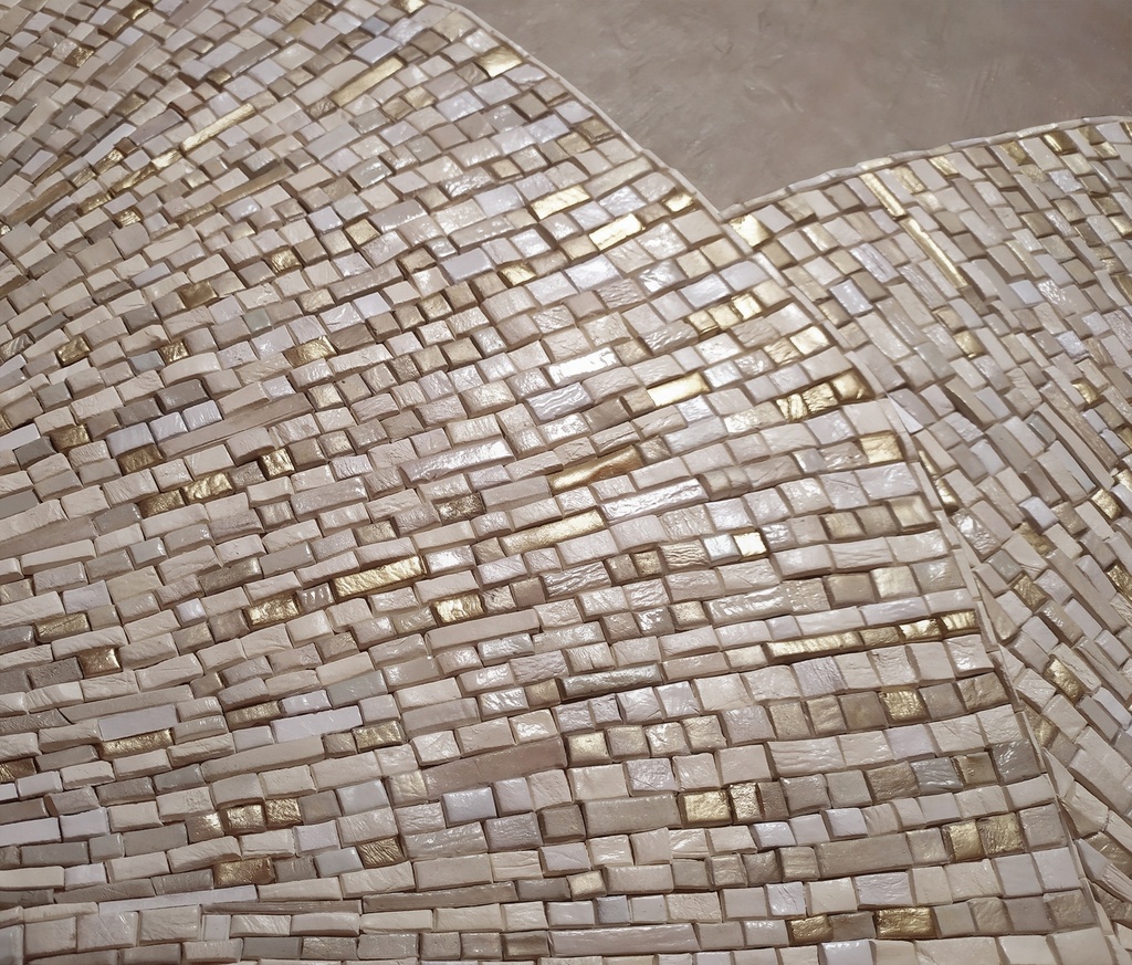 Close up of beige and gold mosaic wall art
