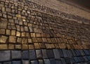 Detail of mosaic wall art with gold, navy blue, copper, and brown tiles